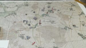 A tactical map with blue and red unit pieces on it.